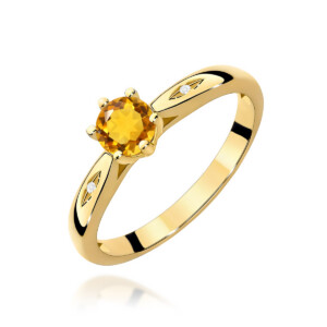 Kihlasõrmus. Yellow gold ring with a round orange gemstone in a prong setting, flanked by small diamonds on the shoulders.