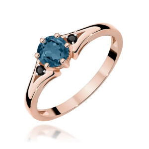 Kihlasõrmus. Rose gold ring featuring a round blue gemstone with small black accent stones on the band
