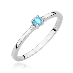 Kihlasõrmus. Silver ring with a round light-blue gemstone held by four prongs and small clear stones on the sides, set on a slim band.