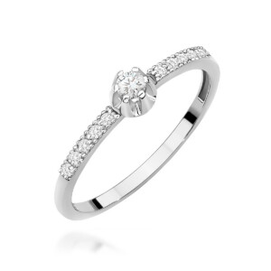 Kihlasõrmus. Elegant white-gold engagement ring with a central round diamond and a pavé diamond band on the shank, viewed at an angle.