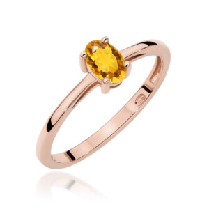 Kihlasõrmus. Rose gold ring with a yellow oval gemstone held by four prongs. The band is smooth and polished.
