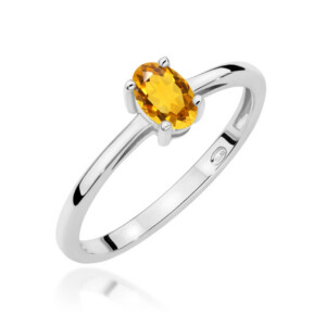 Kihlasõrmus. Silver ring with an oval orange gemstone set in a four-prong setting on a polished band, close-up view.