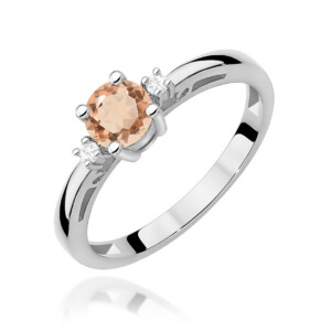 Kihlasõrmus. Silver ring with a peach-colored central gemstone flanked by small diamonds on each side.