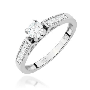 Kihlasõrmus. Silver ring with a central round-cut diamond in a prong setting and small diamonds along the band on both sides to create a sparkling halo effect